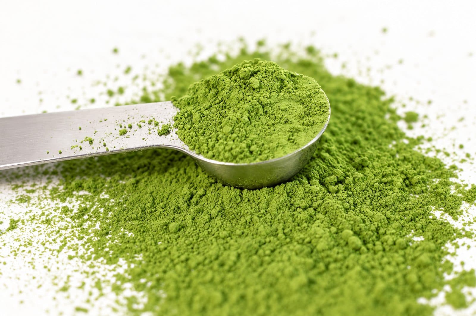Odměrka v čerstvě mletém zářivě zeleném matcha prášku